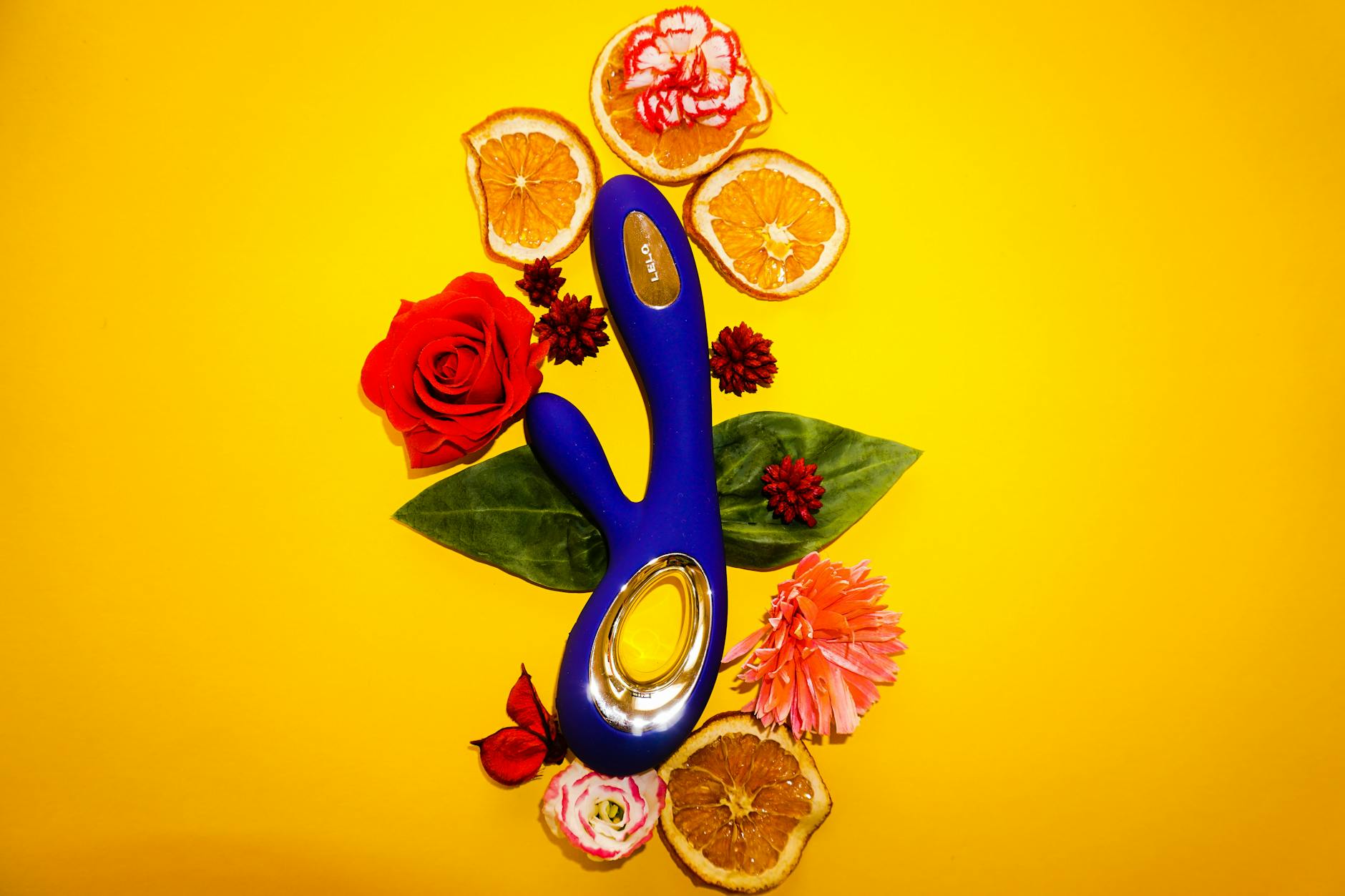 A person holding a blue silicone lemon clitoral vibrator against a purple background, representing shared pleasure and intimacy.